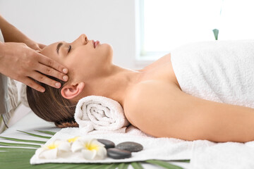 Young woman getting head massage in spa salon, closeup
