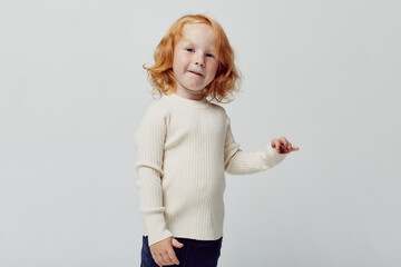 Redhaired girl in white turtleneck sweater portrait on white background with fashion and beauty theme