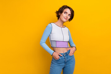 Photo of cute dreamy woman wear top looking empty space smiling isolated yellow color background