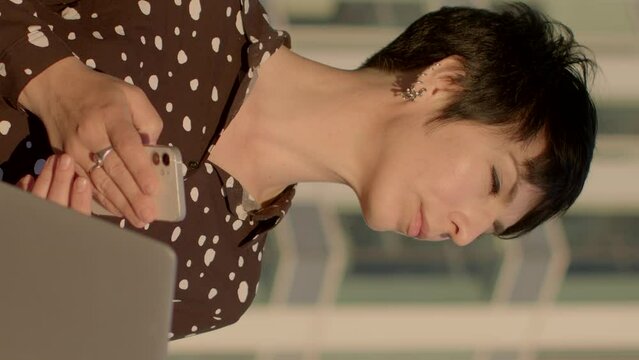 Portrait woman using smartphone against urban backdrop. Technology and modern lifestyle. Sense of connectivity, efficiency, and adaptability humans in the digital era. AI chat bot assistent using.