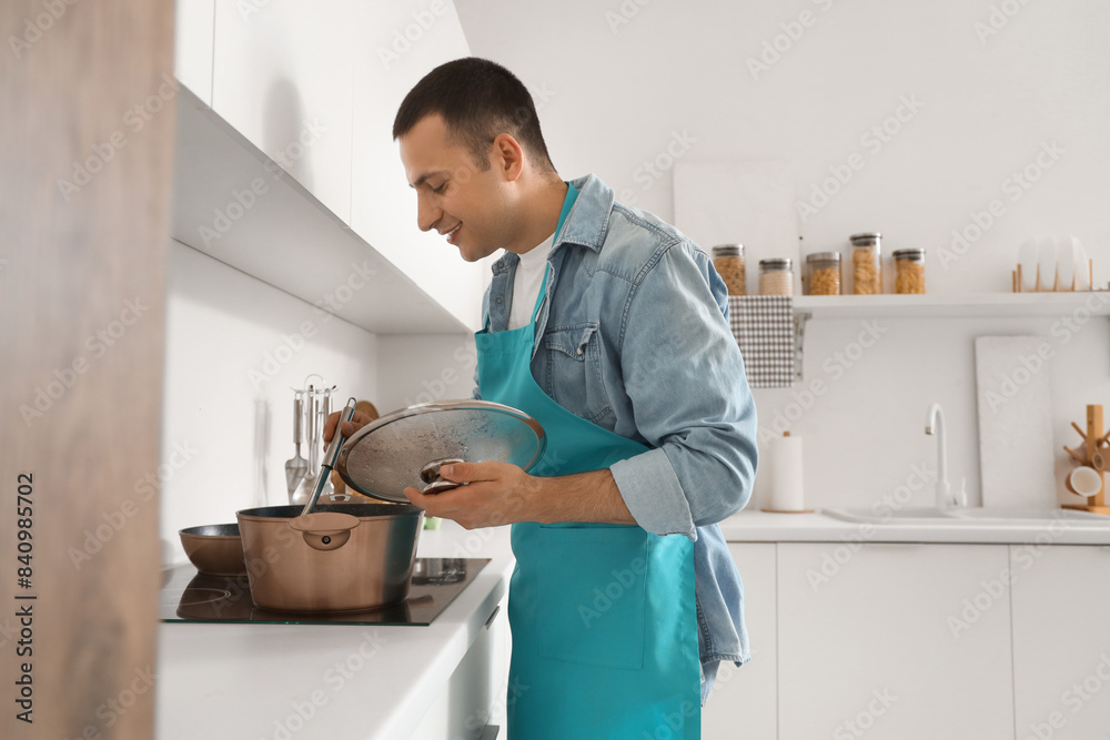 Sticker young man cooking soup on stove in kitchen