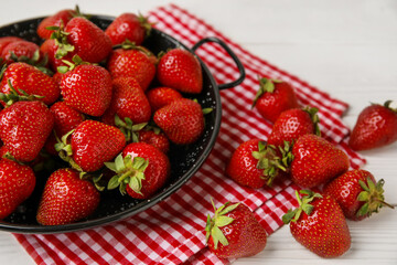 Plate with sweet fresh strawberries on white wooden background