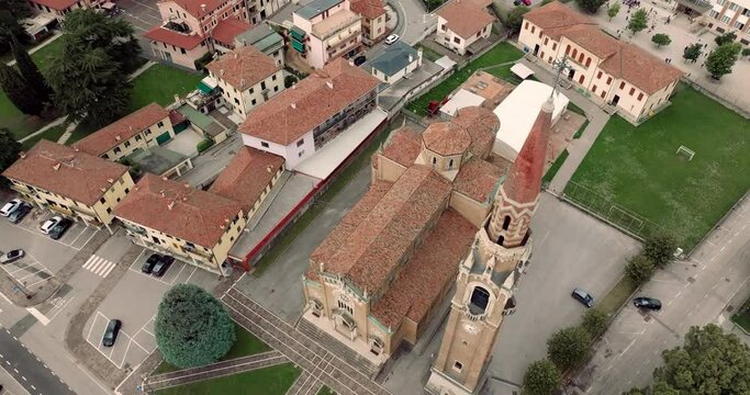 Aerial view cityscape Cornuda Italy. The architecture of the historic cathedral in the central square in mountain glass. High quality 4k footage