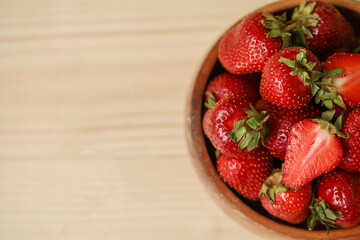 Bowl with sweet fresh strawberries on wooden background