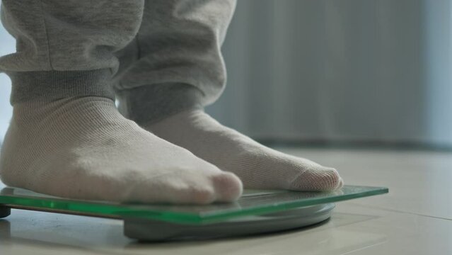 Man feet scales measuring losing weight male legs weighing stepping dieting health body mass digital device control counting wellness sport sportsman balance slimming flooring overweight obesity check