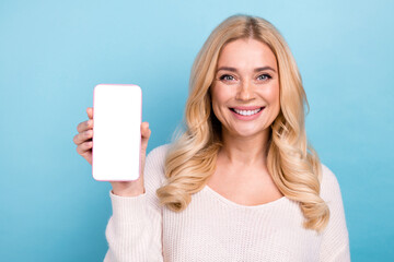 Photo of charming pretty cheerful woman wear trendy clothes hold phone empty space isolated on blue color background