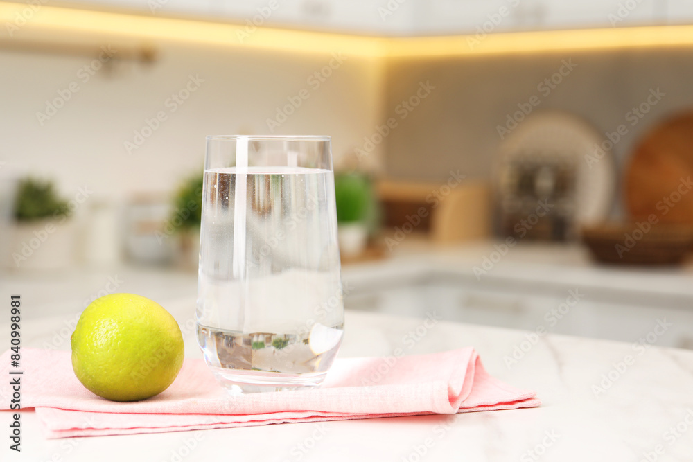 Canvas Prints Filtered water in glass and lime on white marble table in kitchen, closeup. Space for text