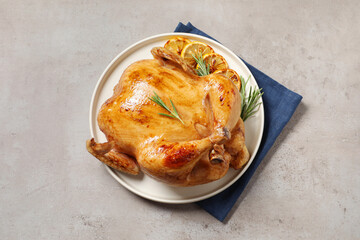 Tasty roasted chicken with rosemary and lemon on light grey table, top view