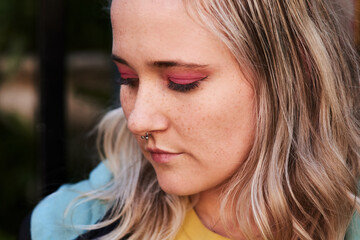 Obraz premium Outdoor thinking, woman and serious with makeup for inspiration, skin glow and idea for edgy beauty. Gen z girl, face and cosmetics with thoughts for piercing and confidence for facial transformation