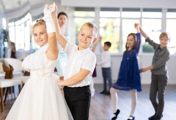 Children dance in pairs at a festive matinee