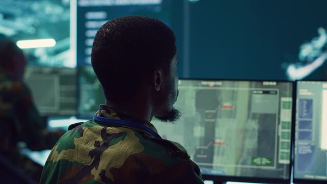 Army officer develops contingency plans to address unexpected developments in the field, studying real time satellite intelligence in military command post. Soldier tracking enemy servers. Camera A.