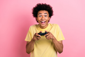 Photo of crazy overjoyed person hands hold controller enjoy playing video games isolated on pink...