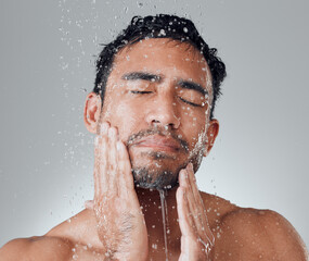 Man, shower and water for washing face in studio, beauty and cleaning or grooming on gray background. Male person, cosmetics and hygiene or dermatology in routine, skincare and facial treatment