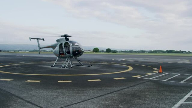 Grounded helicopter on asphalt - wide, steady cam shot