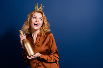 Portrait of dreamy girl with curly hairdo wear blouse crown hold champagne look at sale empty space isolated on dark blue color background