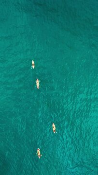 Vertical Screen: Enjoy a scenic aerial view of kayakers paddling in clear turquoise waters. A perfect image for travel and adventure themes, featuring outdoor water sports and natural beauty