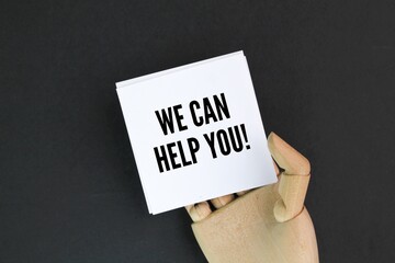 wooden hand and white paper with the words we can help you. the concept of hr or help