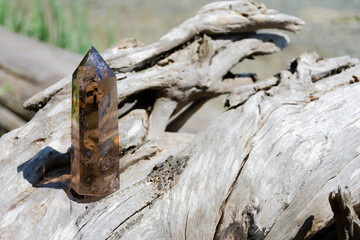 An image of a large smoky quartz crystal tower sparkling in the afternoon sunlight. 