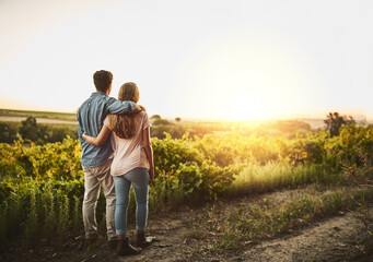 Back, hug and couple in sunrise, field and together with care, love and date for anniversary in...