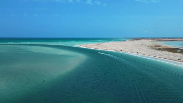 An aerial view of Hassi El Jerbi aquatic beach scene with a boat in the water at Zarzis Tunisia. People are swimming on the beach, enjoying their time near the water.
