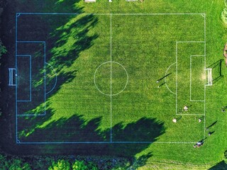 Aerial view of soccer players playing soccer and training on a outdoor green field. © VisualArtStudio