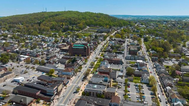 Aerial hyperlapse over American town in spring. Drone time lapse of traffic on main street of quaint USA town.