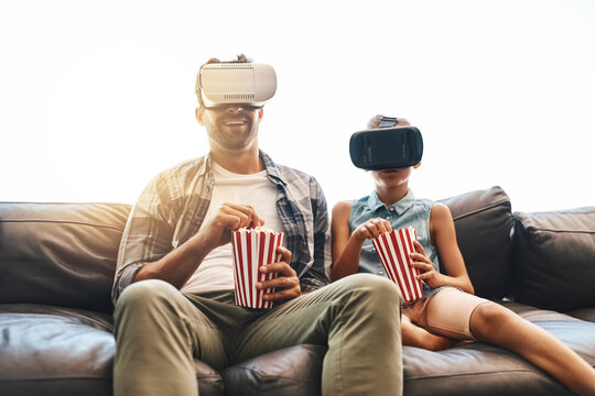 VR, father and girl on sofa with popcorn for futuristic, streaming movies or entertainment in living room. Lens flare, metaverse and young child for simulation, augmented reality or film in home