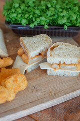 Close up of sandwich slices with cheese on wooden cutting board