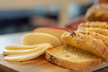 Close up of bread and cheese slices on wooden cutting board