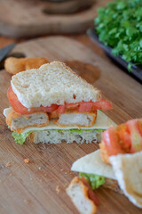Close up of sandwich slices with cheese on wooden cutting board