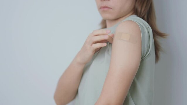 Woman with bandage after receiving vaccine. Vaccination and Immunization for Influenza, HPV, Zoster, IPD, DTP or Diphtheria, Tetanus and Pertussis, MMR, Hepatitis B, Covid  and Varicella vaccine