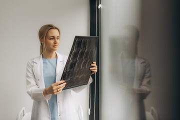 Fototapeta premium MRI digital x-ray of brain with radiologist doctor oncology working in clinic hospital. Medical healthcare concept. Medical experts studies the EEG condition of the patient. Doctors Examining X-Ray