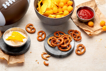 Snacks for watching an American football game. Beer, chips, pretzels, sauce on wooden background