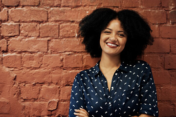 Portrait, happy and business woman on brick wall space for career or job at creative startup...