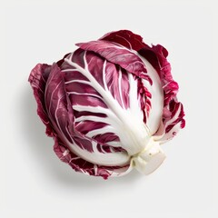 Obraz premium A single head of red radicchio sits on a white background. The radicchio is a bright red with white veins and has a slightly ruffled texture