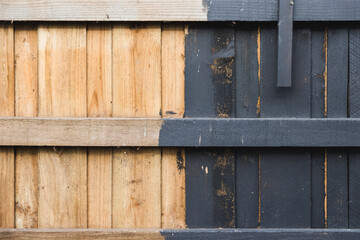 half painted backyard retaining wall or fence, charcoal vs bare wood, home improvement and renovation