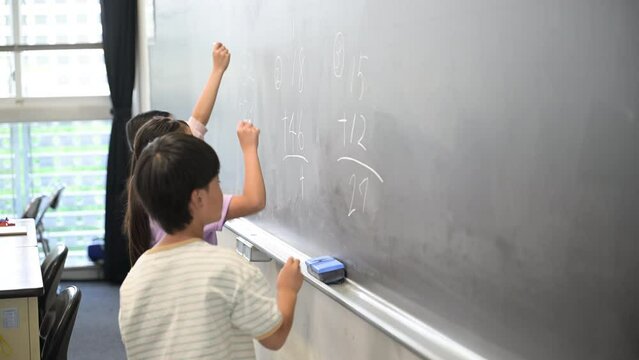 黒板で算数を勉強する小学生複数の横顔の動画