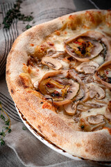 A homemade pizza with mushrooms, cheese, and meat rolls is featu