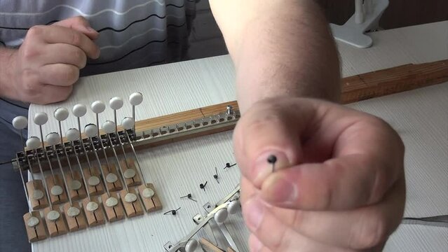 Repair of accordion. A man disassembles a block of accordion keys. Professional repair service specializing in the restoration of musical instrument accordion