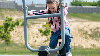 Obraz premium cute kid, little child girl exercising on sport ground