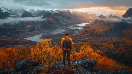Obraz premium man is far away, standing with his back against the backdrop of the huge mountains in Lofoten.