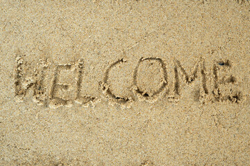 Welcome text on beach sand background
