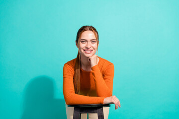 Portrait of minded clever woman with foxy hair wear crop top lean on chair hold hand under chin...