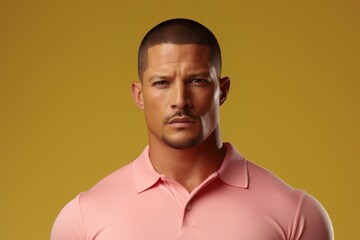 Obraz premium A man with a shaved head and a mustache is wearing a pink shirt