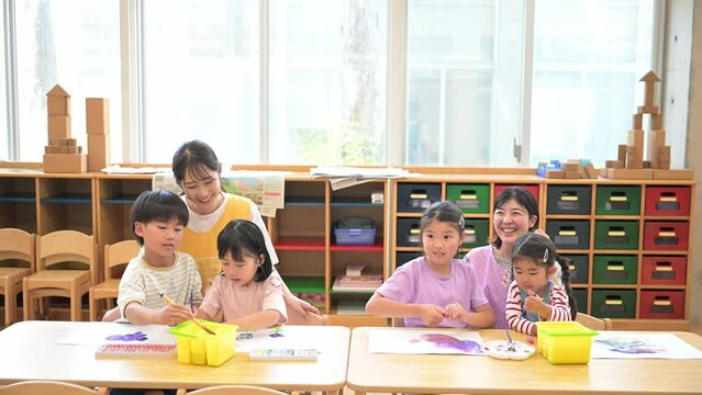 学童や放課後デイサービス等で勉強をする先生と生徒　小学生複数の動画の広角