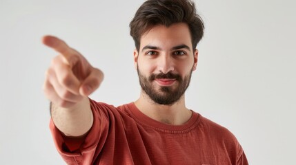 Confident young man with a beard pointing finger towards viewer on white background
