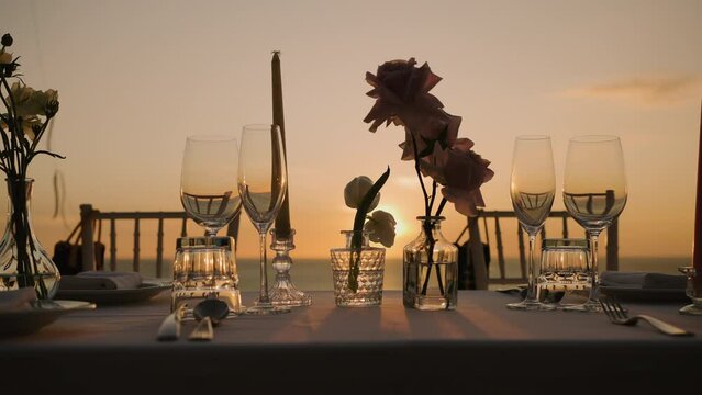Close up decoration flowers candles wedding reception party outdoor romantic dinner sunset.

