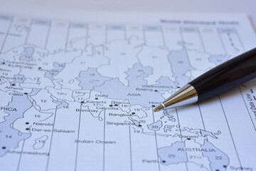 Black shiny premiuvLuxury black pen pointing to world map. Macro photo shot, shallow depth of field