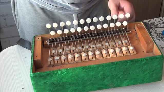 Repair of accordion. A man sets the keyboard block into the accordion. Close-up of a man adjusting the keys of a grand accordion for optimal performance