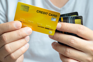 Man holding several credit cards and he is choosing a credit card to pay and spend Payment for goods via credit card. Finance and banking concept	

